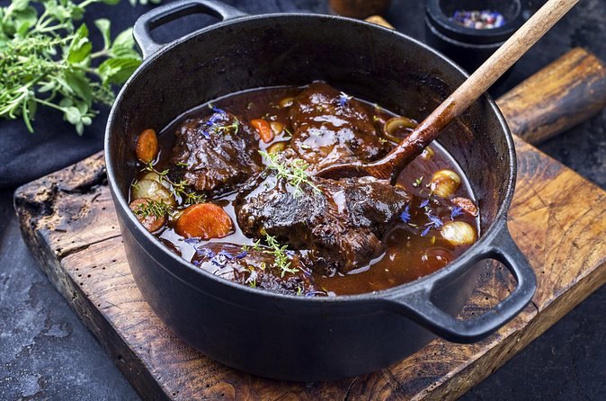 A cast-iron pot of beef bourguignon served on a Montmartre food tour