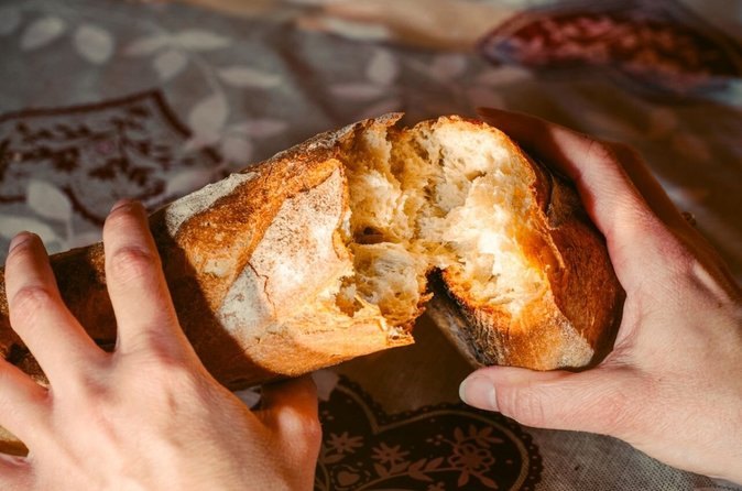A fresh baguette broken open at a bakery stop on a Montmartre food tour
