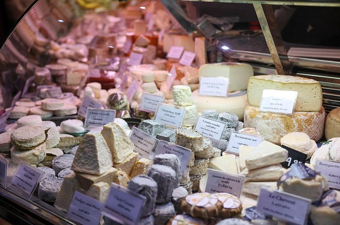 A cheese counter stacked with French rounds on a Montmartre food tour
