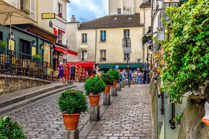 A cobbled Montmartre lane lined with potted bay trees