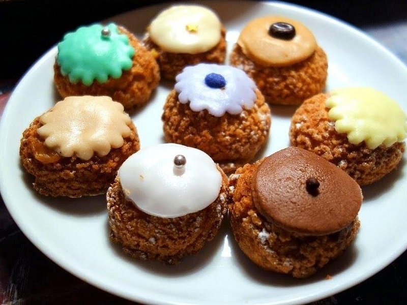 Iced choux pastries on a plate at a stop on a Montmartre food tour