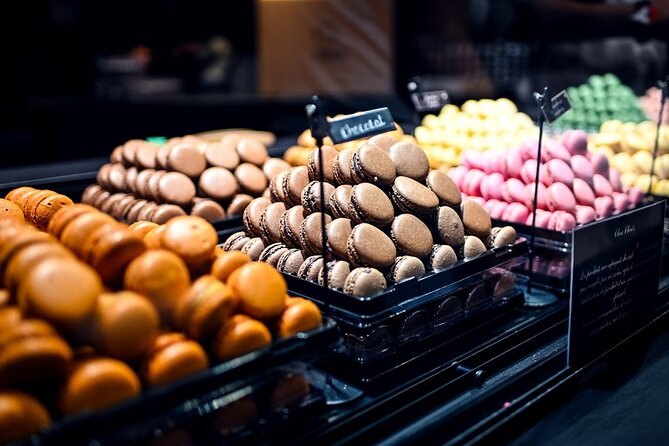 Rows of macarons and choux buns in a Montmartre pâtisserie window
