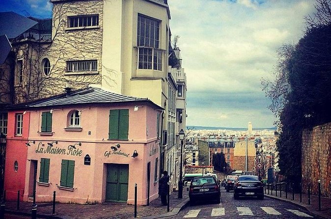 A pale corner house with green shutters on a quiet Montmartre street